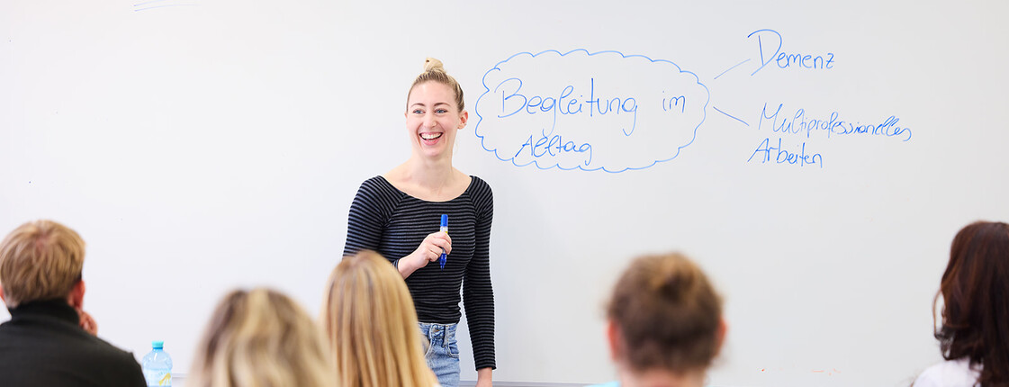Eine Lehrende steht vor einer Klasse im Caritas Ausbildungszentrum Seegasse