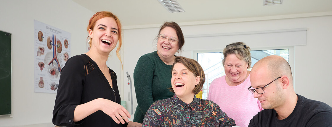 Gruppe Schüler*innen verbindet den Arm eines Mitschülers