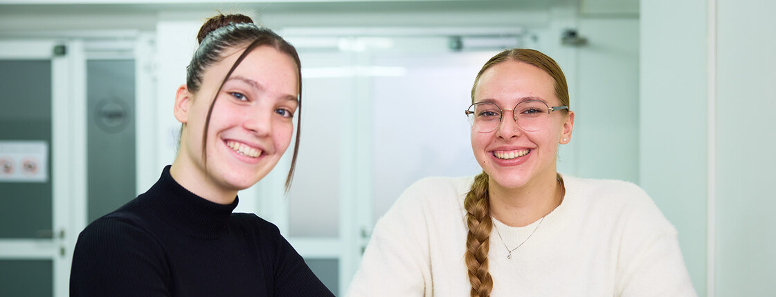 Zwei junge Frauen lächeln in die Kamera