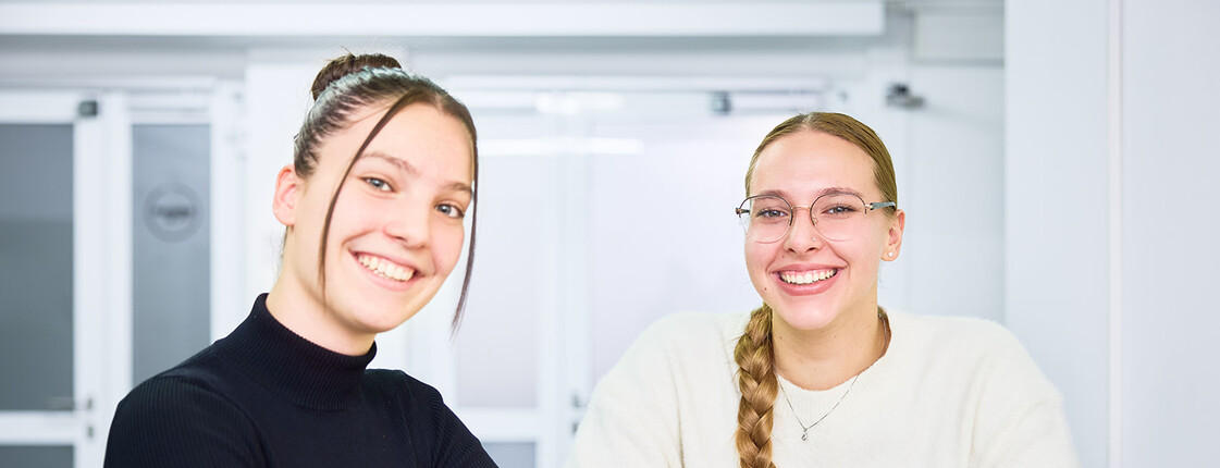 Zwei junge Frauen lächeln in die Kamera