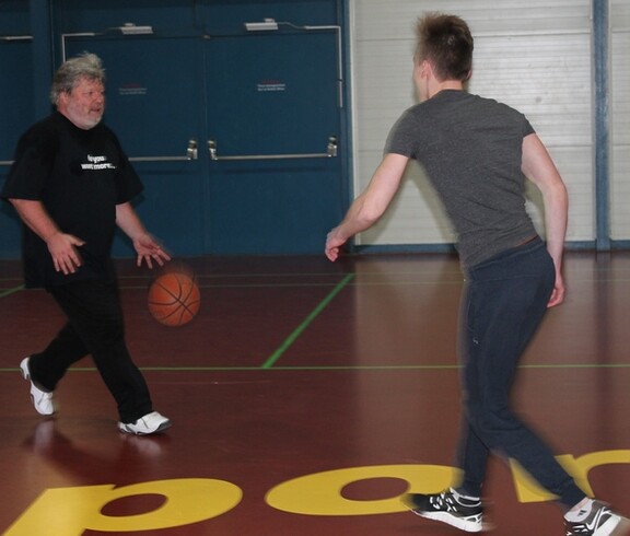 Schüler und Lehrer spielen Basketball
