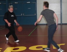 Schüler und Lehrer spielen Basketball